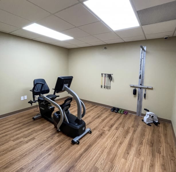 A small gym room featuring an exercise bike and fitness equipment.