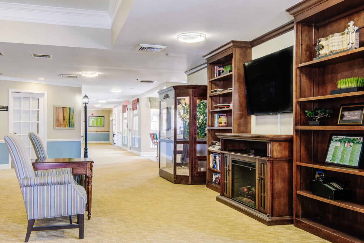 A cozy living area with wooden bookshelves, a television, and a fireplace.