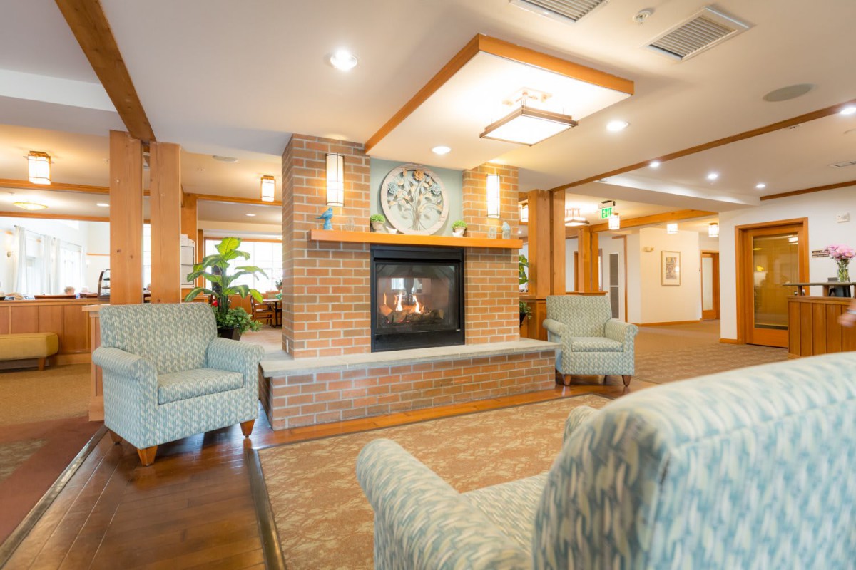 A cozy hotel lobby with comfortable seating and a warm fireplace.