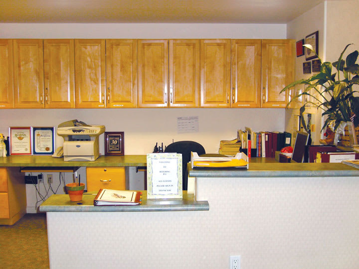 A well-organized reception desk with cabinets and office supplies.