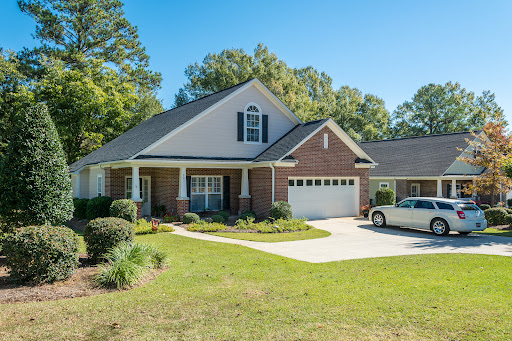 A charming residential house with a well-maintained lawn and driveway.