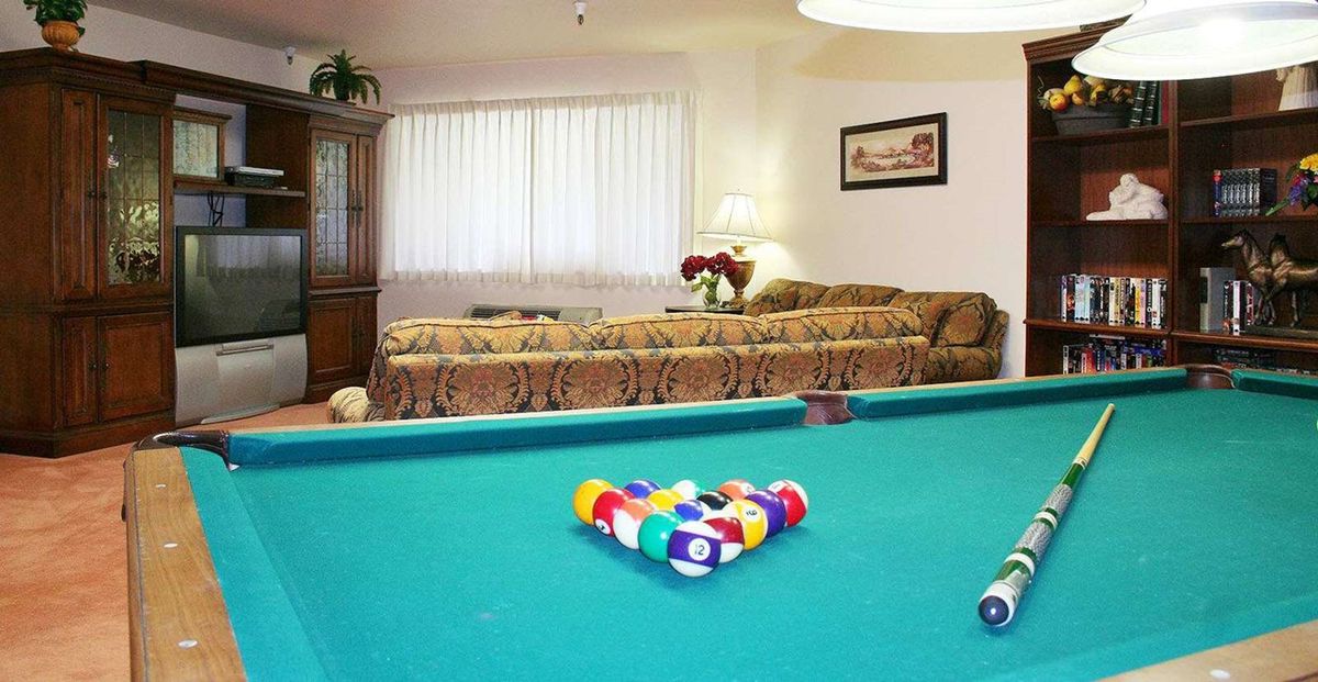 A cozy living room with a pool table and comfortable seating.