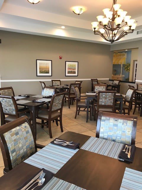 A modern dining area with neatly arranged tables and chairs, featuring tasteful decor.