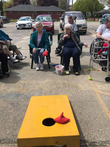 Seniors enjoying a lively game of cornhole in the community.
