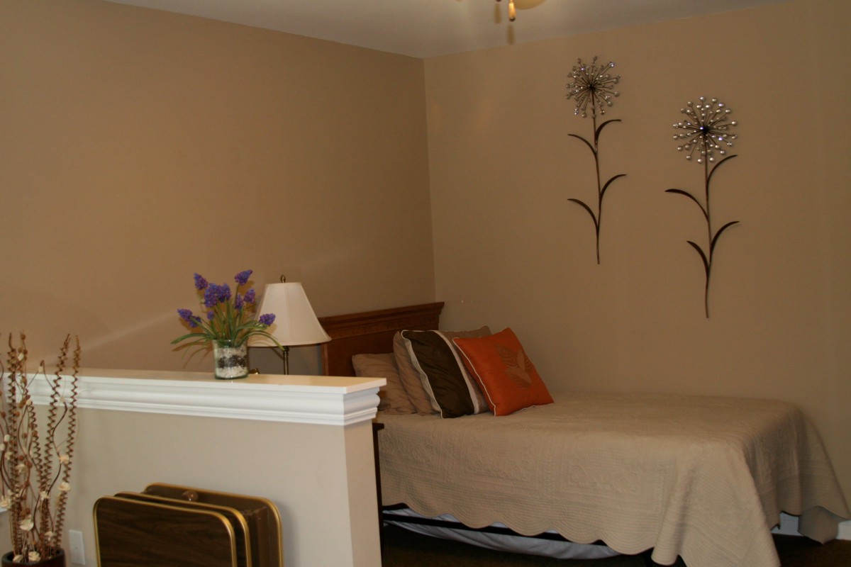 A cozy bedroom with decorative wall art and a neatly made bed.