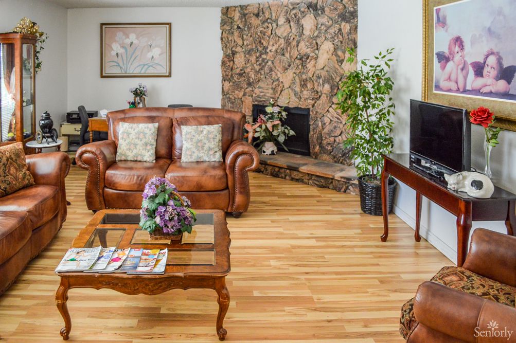 A cozy living room with a leather sofa, fireplace, and hardwood floors.