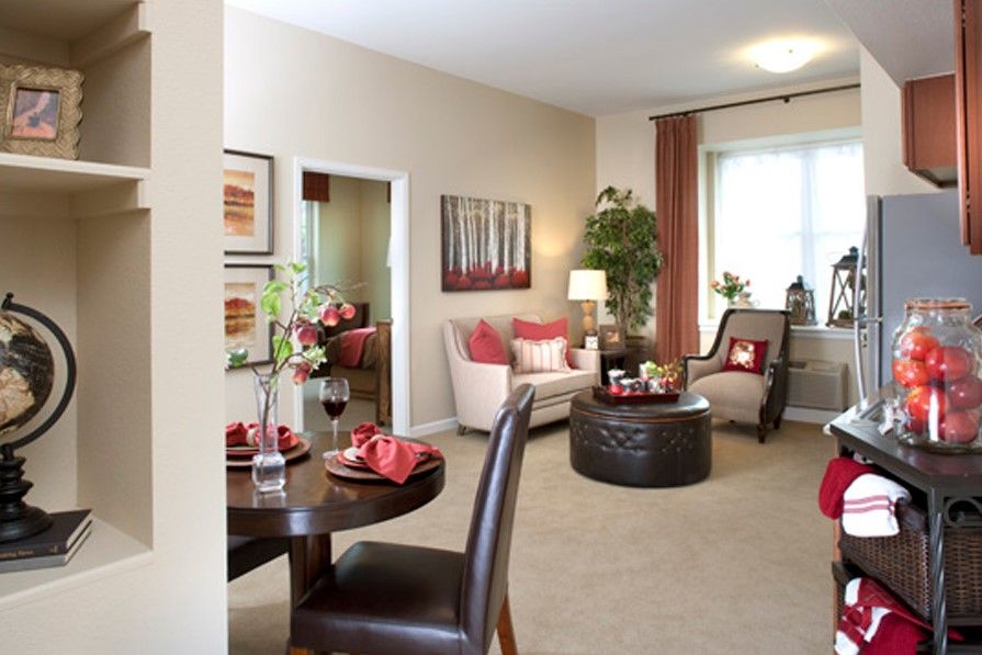 A cozy living room with modern decor, featuring armchairs, a coffee table, and decorative plants.