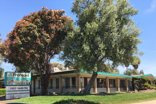 A charming building surrounded by lush trees and clear blue skies.