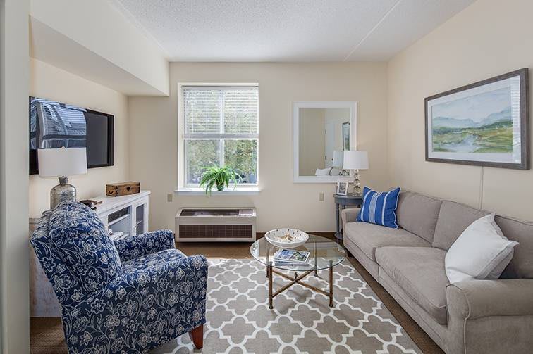 A cozy living room with a sofa, armchair, and stylish decor.