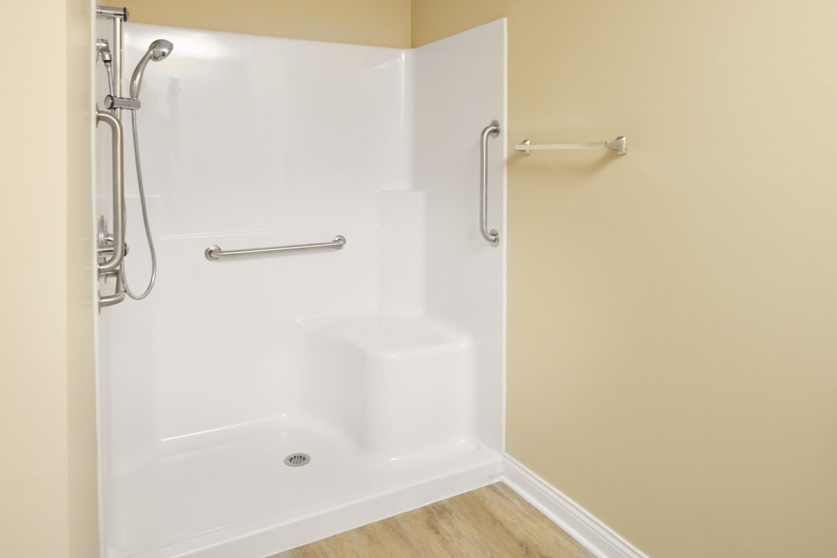 An accessible shower with grab bars and a built-in seat.
