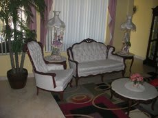 A vintage-style living room with a sofa, armchair, and decorative elements.