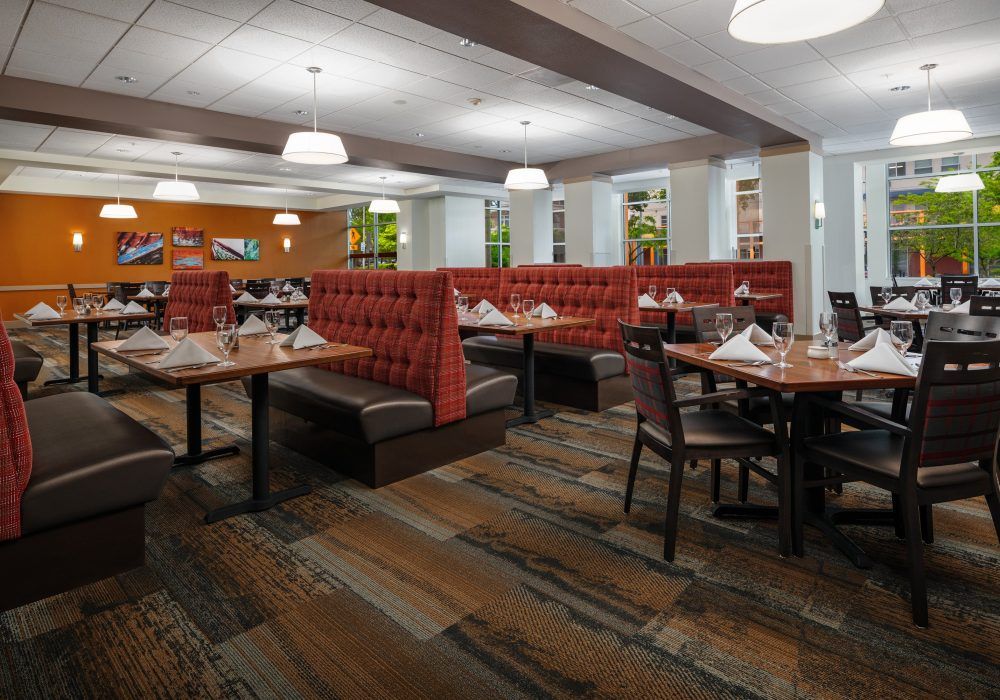 A modern restaurant dining area with booths and tables, featuring stylish lighting fixtures.