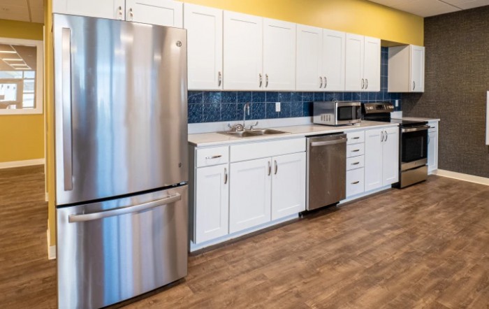 A modern kitchen with stainless steel appliances and white cabinetry.