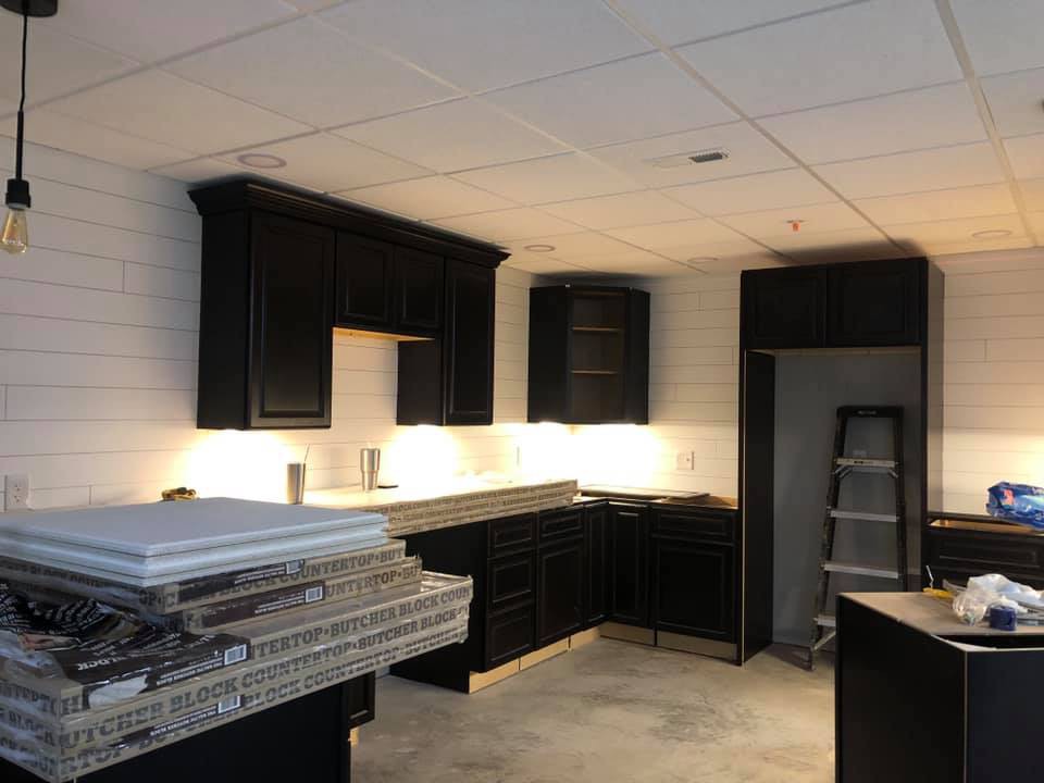 A partially renovated kitchen with dark cabinets and countertops awaiting installation.