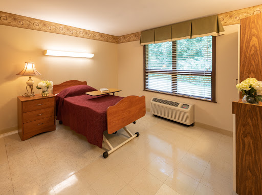 A well-lit hospital room featuring two beds with a simple and functional design.