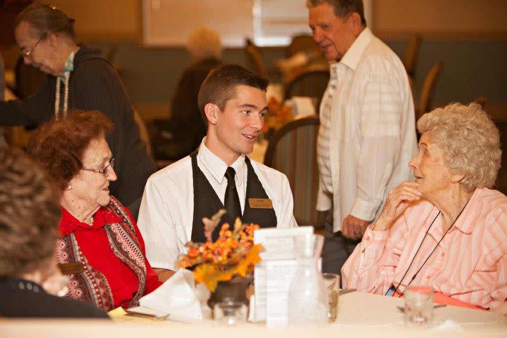 A group of people engaged in conversation at a dining event.