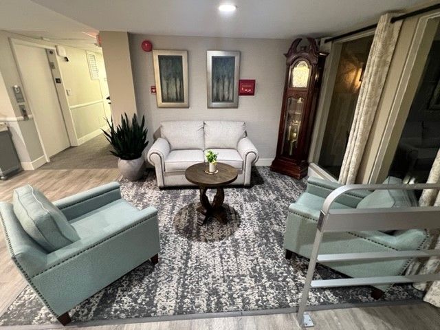 Cozy living area with a sofa, chairs, and a grandfather clock.