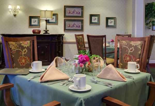 Elegantly set dining table with flowers and folded napkins.