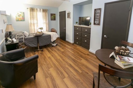 A cozy room featuring a neatly made bed, a small dining table, and modern furnishings.
