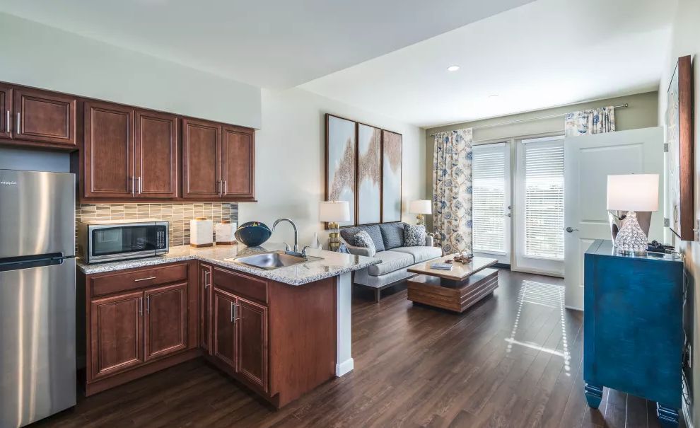 Modern open-concept kitchen and living room with hardwood floors.