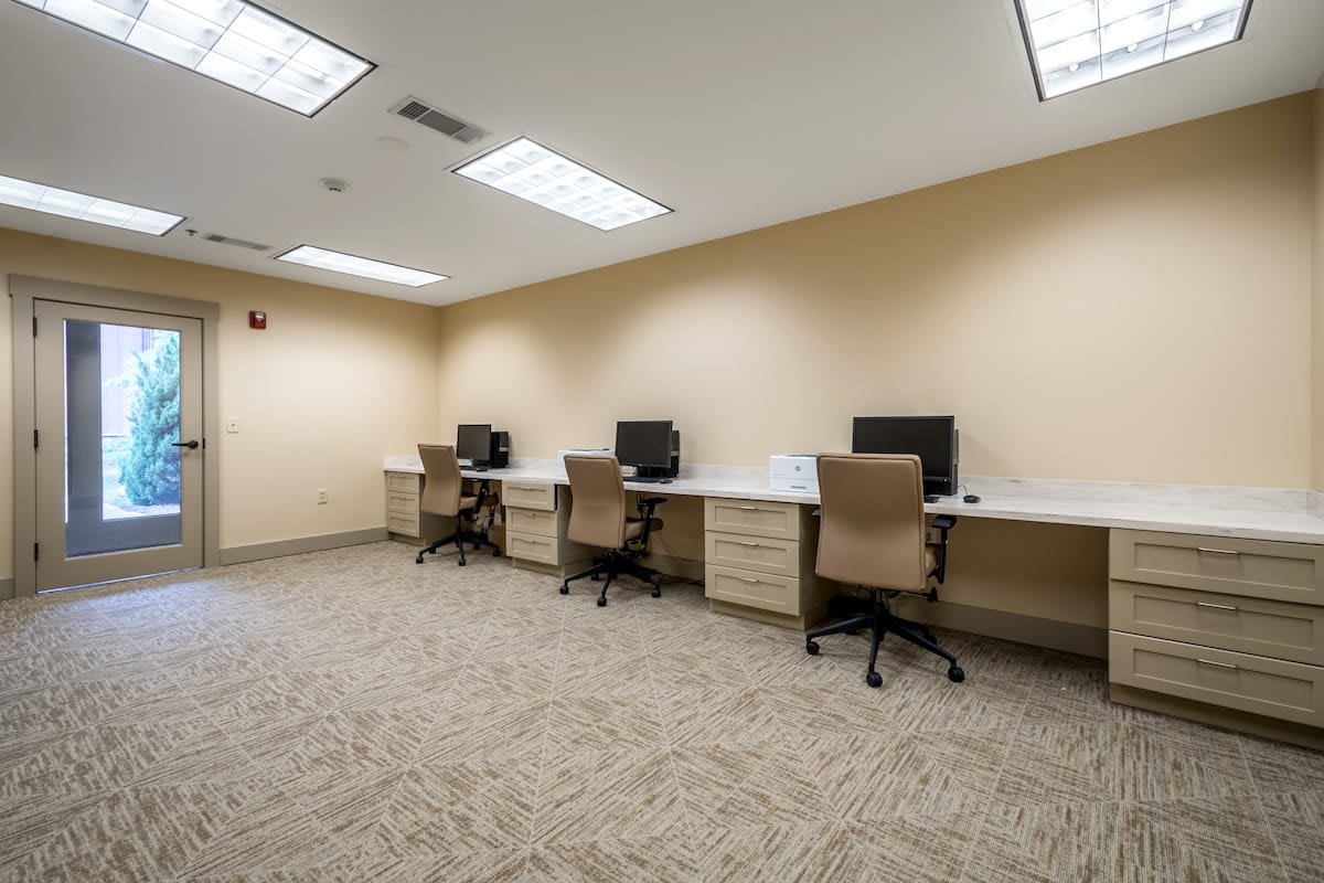 A quiet office space with multiple workstations equipped with computers.