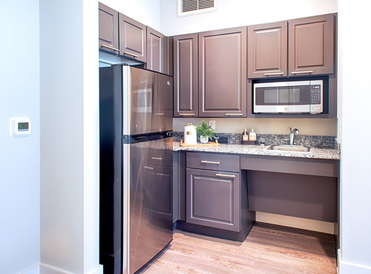 A modern kitchen featuring stainless steel appliances and wooden cabinets.