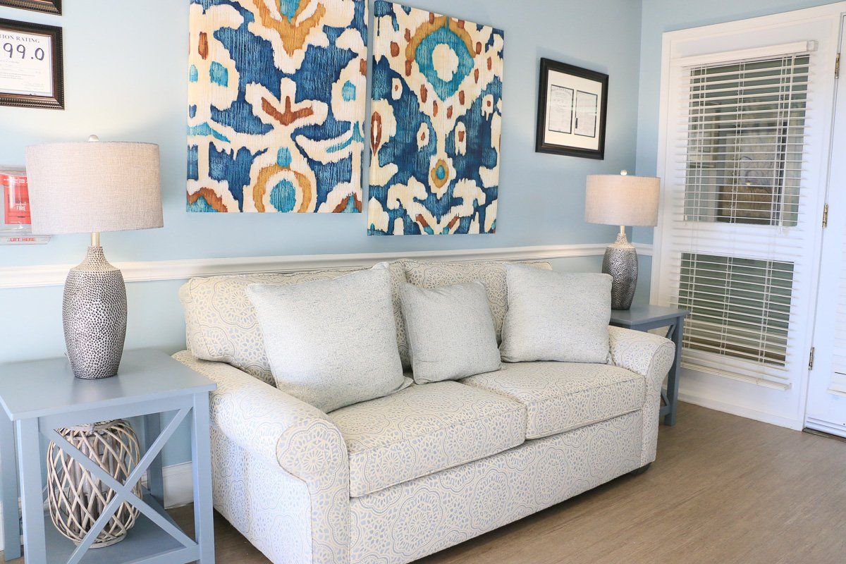 A cozy living room with a light-colored sofa, vibrant wall art, and matching lamps.