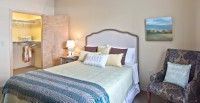 A cozy and well-decorated bedroom with a comfortable bed and bedside lamp.