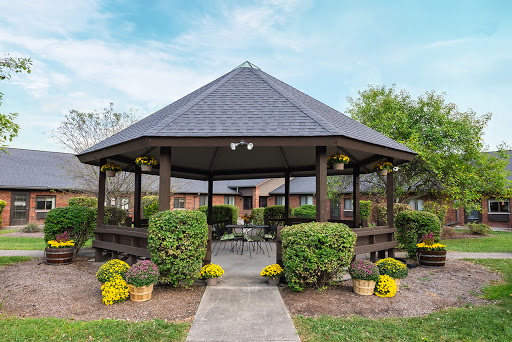 A serene gazebo surrounded by lush greenery and vibrant flowers, perfect for relaxation and enjoying nature.