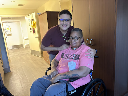 A caring moment between a caregiver and an elderly individual, both smiling for the photo.