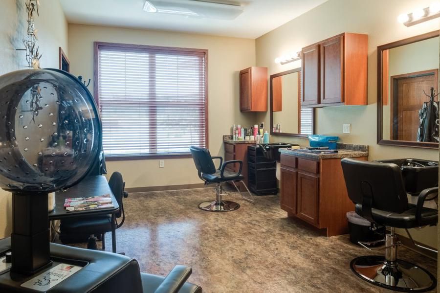 A tidy and well-lit hair salon with styling stations and chairs.