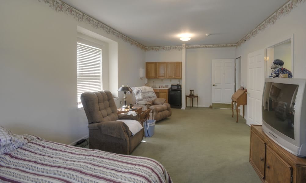 A cozy living room with reclining chairs and a kitchenette.