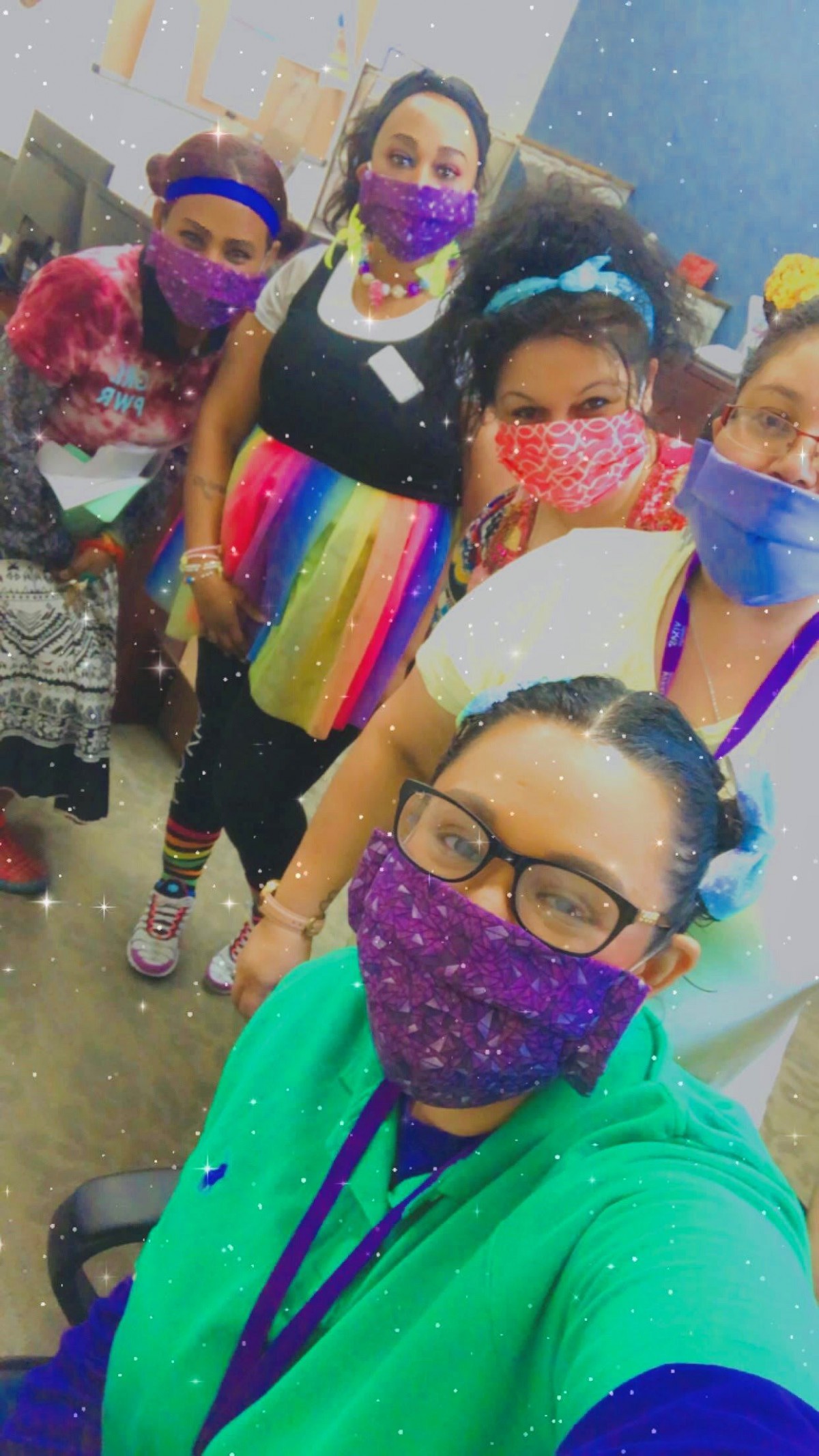 A colorful indoor gathering of women wearing masks.