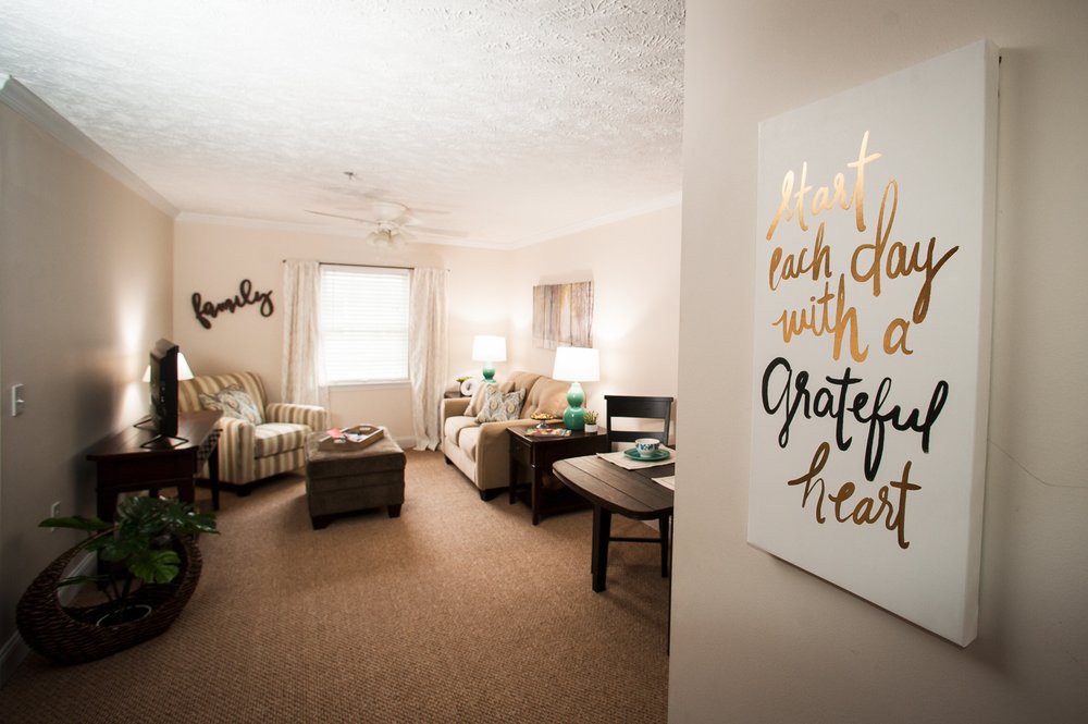 A cozy living room with comfortable furniture and decorative wall art.