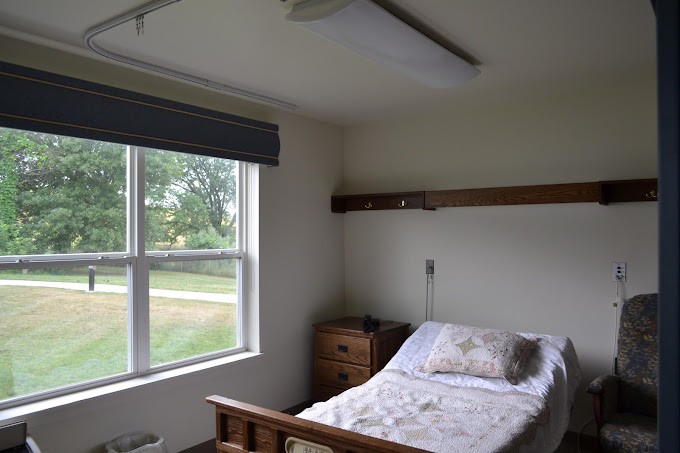 A simple bedroom with a single bed next to a window.