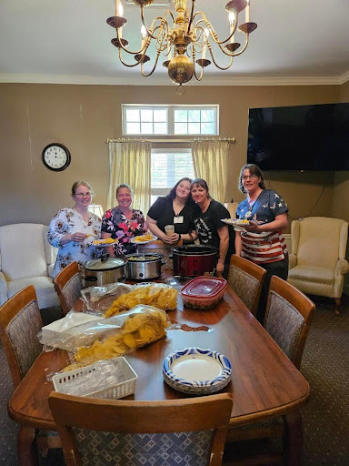 A joyful gathering of friends cooking and sharing delicious food together.