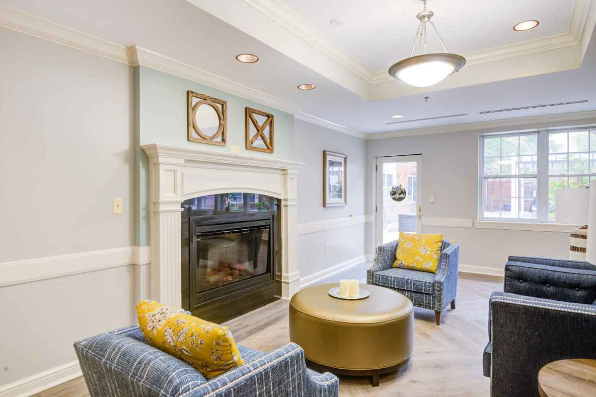 A cozy and modern living room featuring a fireplace, stylish armchairs, and a circular coffee table.