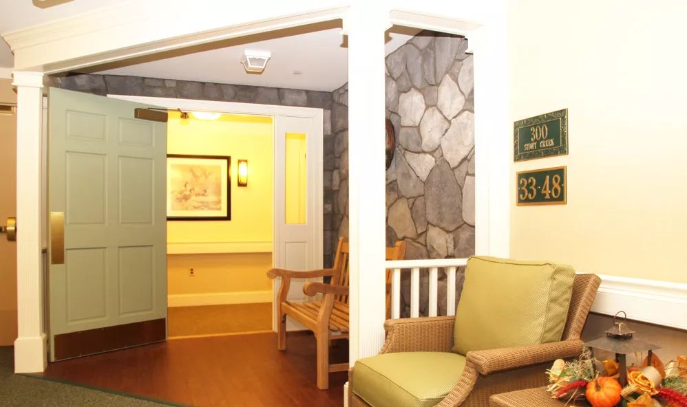 A cozy waiting area with wooden chairs and a stone accent wall.