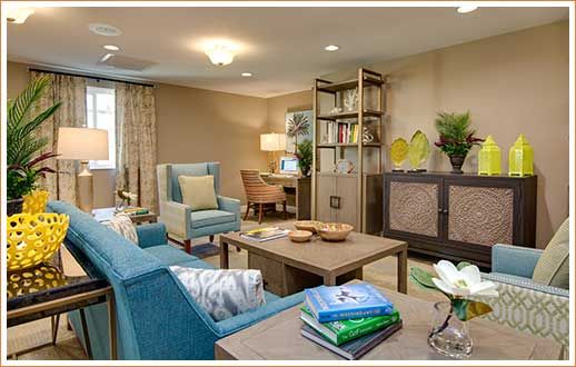 A cozy and well-decorated living room with a blue sofa, armchair, and modern furniture arrangement.
