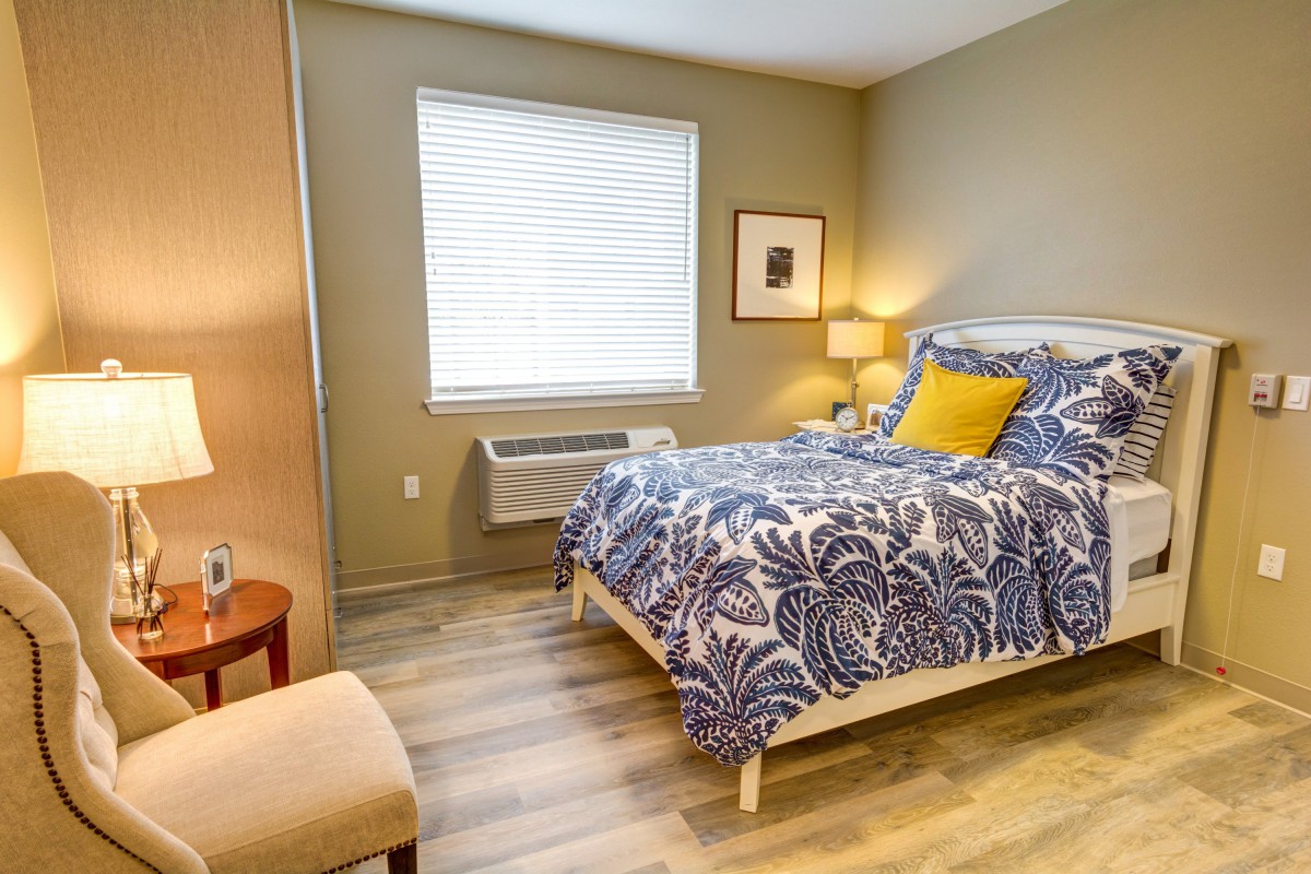 A cozy bedroom with a patterned bedspread and soft lighting.