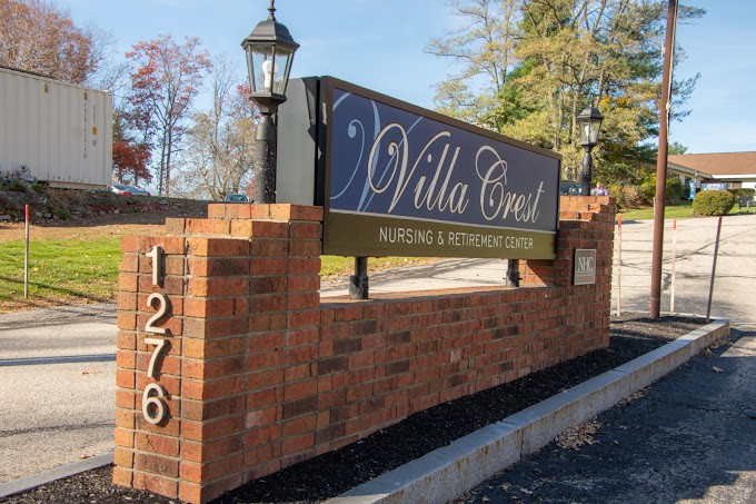 The image shows an outdoor brick sign for 'Villa Crest', indicating a building or community entrance.
