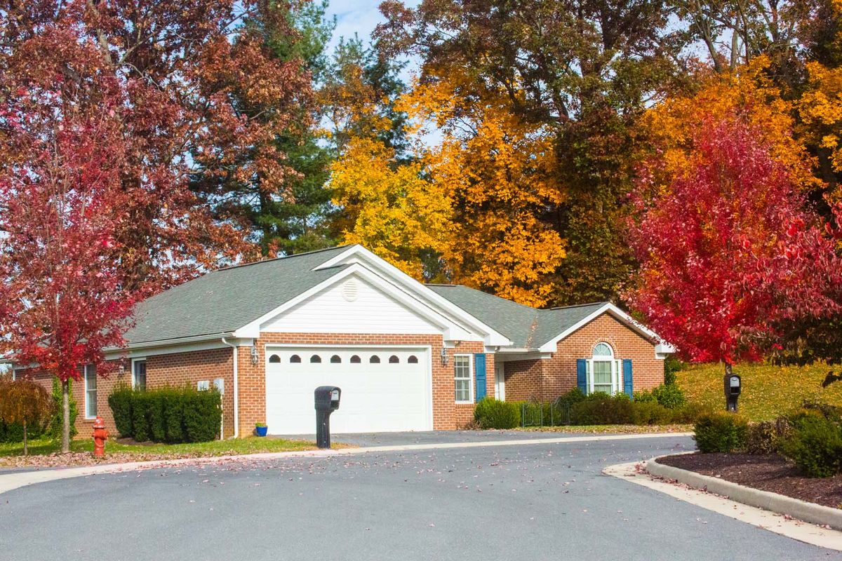 A suburban house surrounded by vibrant autumn foliage.