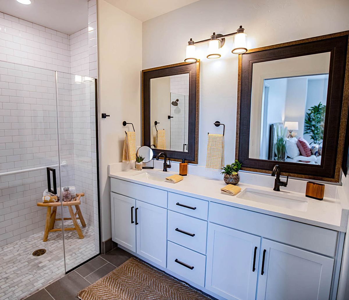 A modern bathroom featuring a double sink vanity with mirrors and stylish lighting.