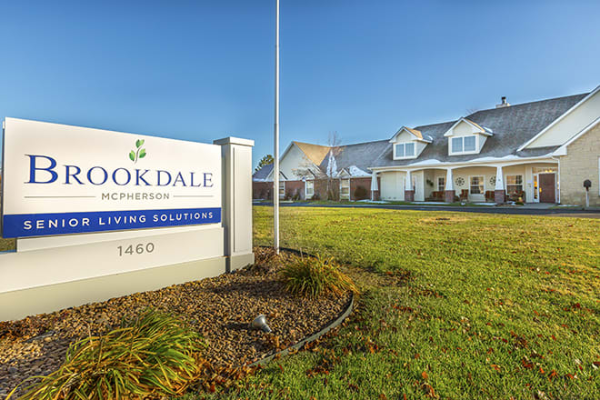 A facility with a sign labeled 'Brookdale' and a well-maintained lawn under a clear blue sky.