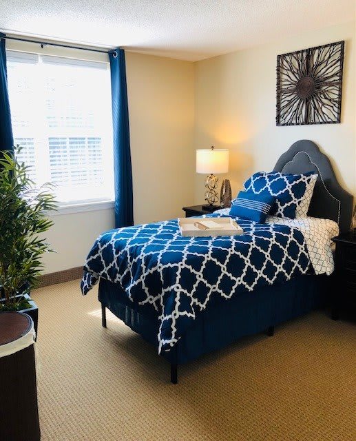 A modern bedroom with blue geometric bedding and stylish decor.
