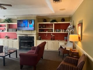 A cozy living room with a TV, fireplace, and comfortable seating.