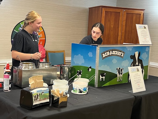 Two individuals serving Ben & Jerry's ice cream at an event.