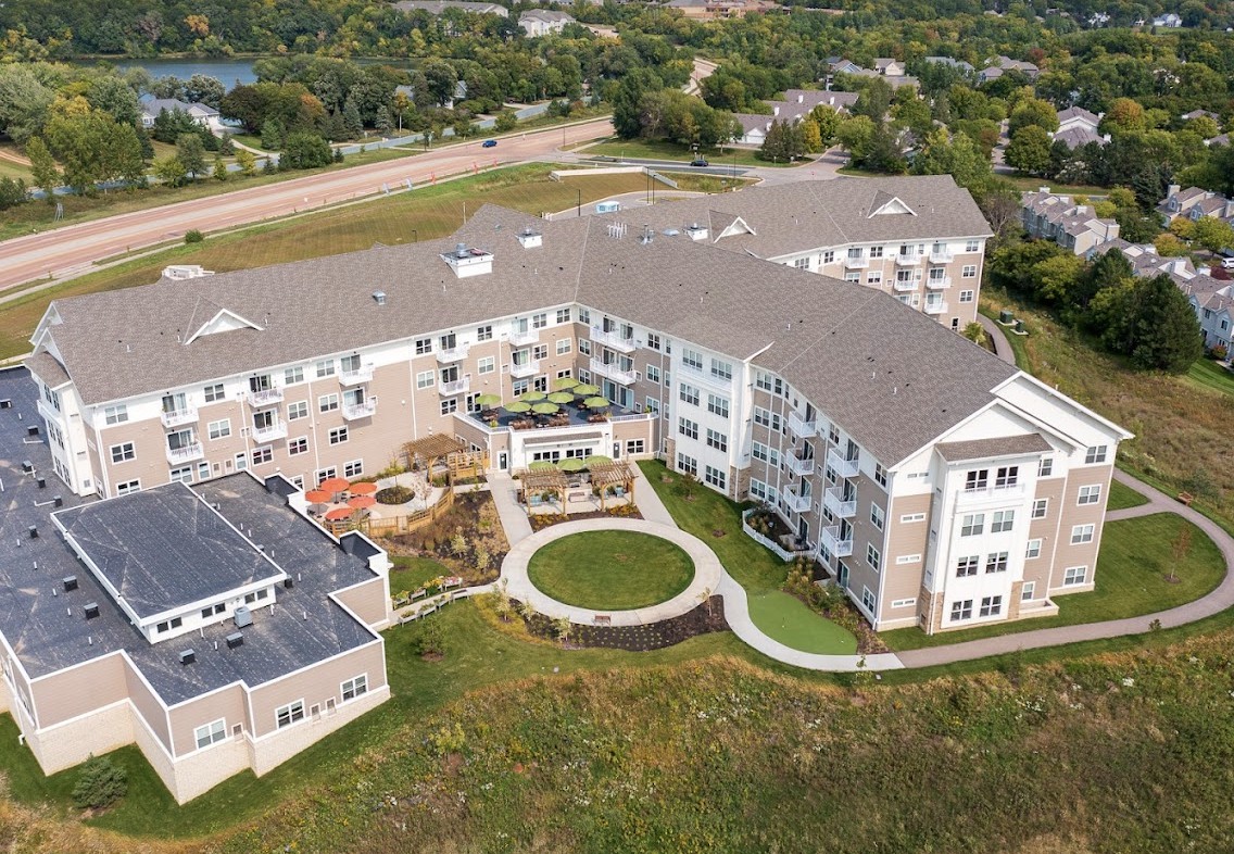 Aerial view of a large residential building surrounded by greenery and pathways.