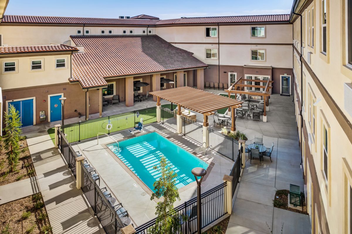 An outdoor courtyard at a hotel featuring a swimming pool and seating area.
