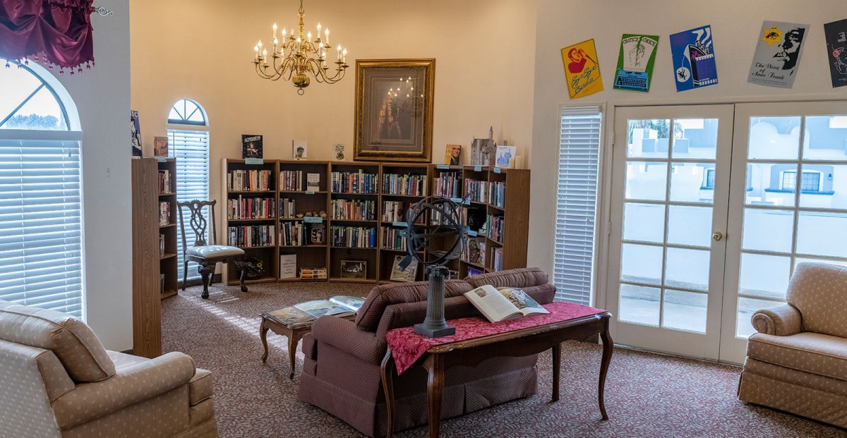 A cozy library with bookshelves and a chandelier, creating a warm reading environment.